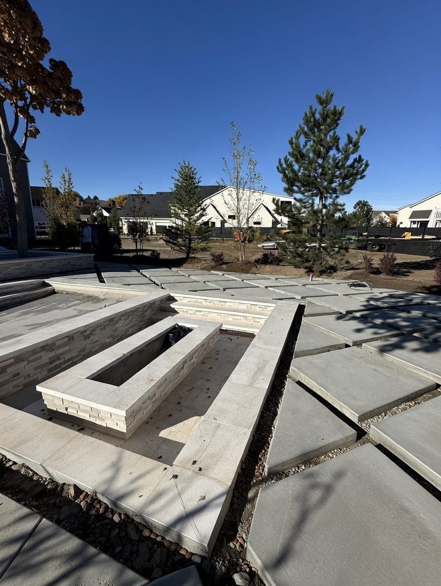 Large-format concrete pavers and stone-clad fire feature in a new residential courtyard